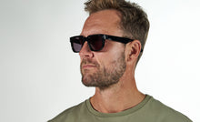 Load image into Gallery viewer, PREGO solbrille i farven Stellar Black fremstillet af bomuldsbaseret acetat. Vores kendte kvalitet giver mulighed for individuelt tilpasning så din solbrille altid sidder perfekt. De matchende grå solglas beskytter øjnene mod solens skadelige UV stråler. Har du brug for styrke i dine PREGO solbriller så kontakt din lokale optiker. Vi samarbejder internationalt med de bedste optikere.